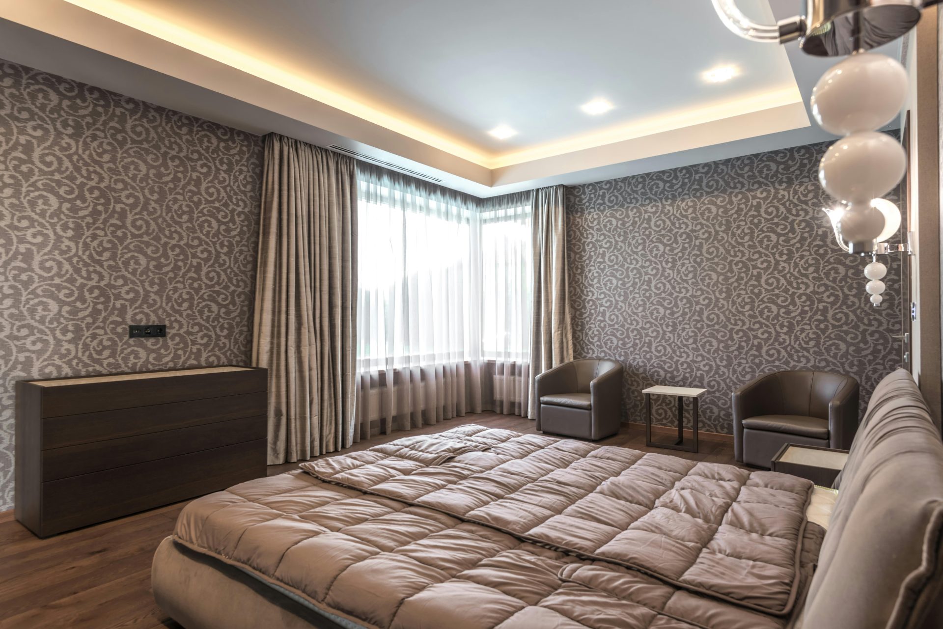 Spacious modern bedroom featuring elegant decor and luxurious furnishings.